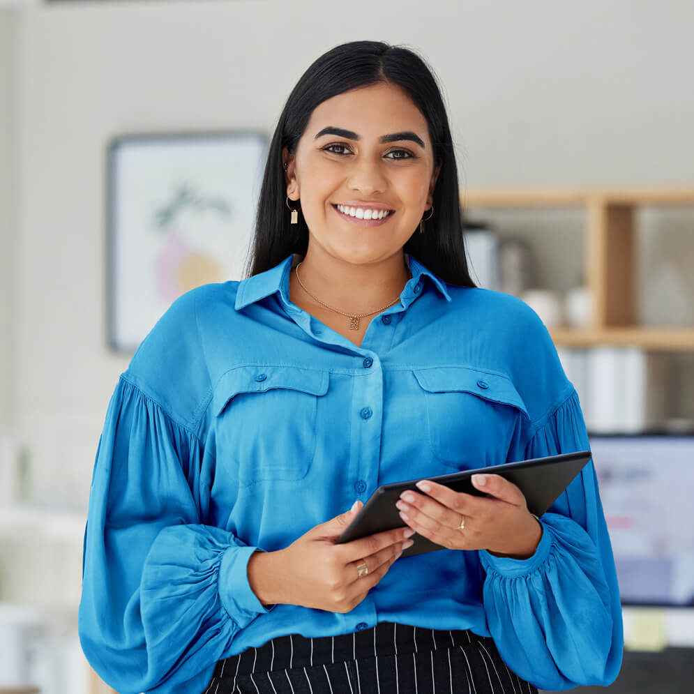 Smiling professional holding a tablet, representing TinyEYE's online therapy services for schools and therapists.